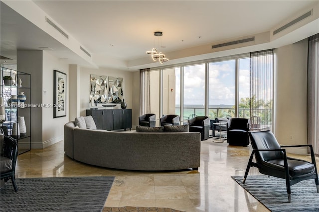 living room featuring a tray ceiling, visible vents, and baseboards