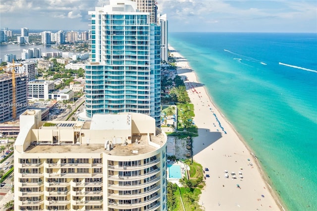 birds eye view of property with a beach view, a water view, and a city view