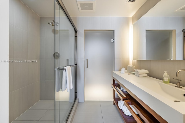 bathroom with tile patterned flooring, vanity, and a shower with door