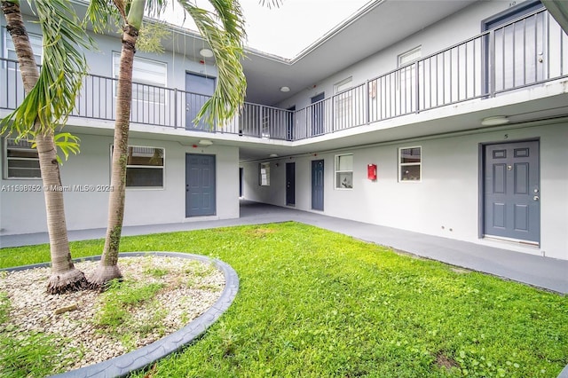 exterior space featuring a lawn and a balcony