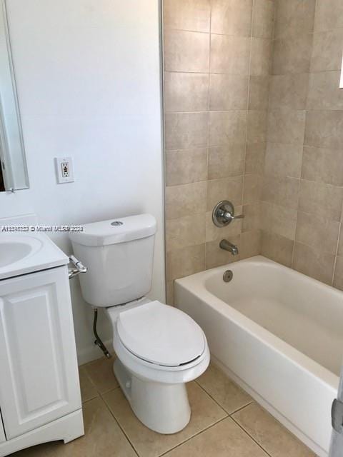 full bathroom with tile patterned floors, tiled shower / bath combo, vanity, and toilet