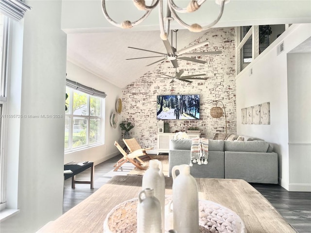 living room with ceiling fan with notable chandelier, dark hardwood / wood-style flooring, and vaulted ceiling