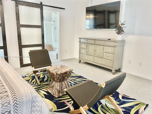 bedroom with a barn door and light colored carpet