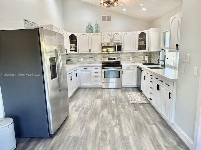 kitchen featuring stainless steel appliances, light wood-type flooring, sink, and backsplash