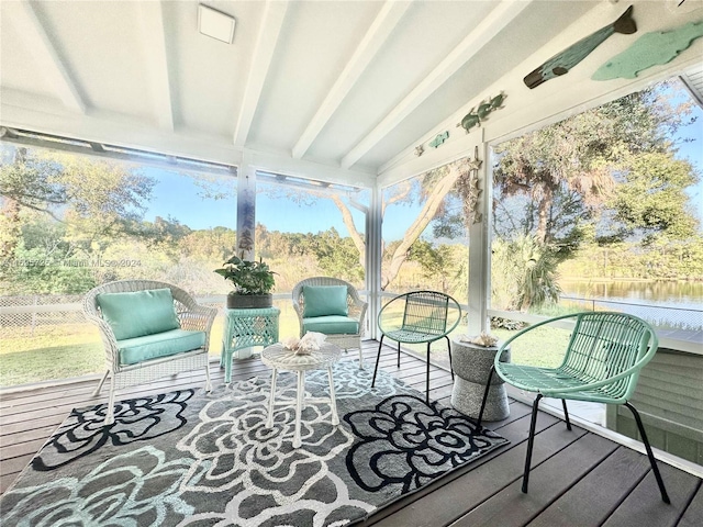 sunroom / solarium featuring a wealth of natural light, vaulted ceiling with beams, and a water view