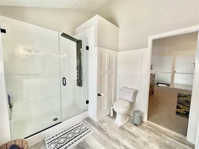 bathroom with walk in shower, lofted ceiling, wood-type flooring, and toilet