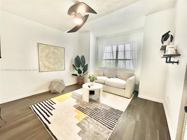 living room with ceiling fan and dark hardwood / wood-style flooring