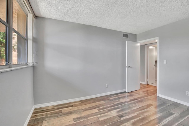 empty room featuring a textured ceiling and wood-type flooring