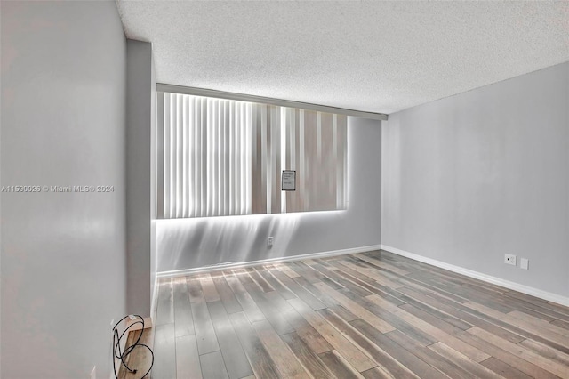 unfurnished room featuring a textured ceiling and wood-type flooring