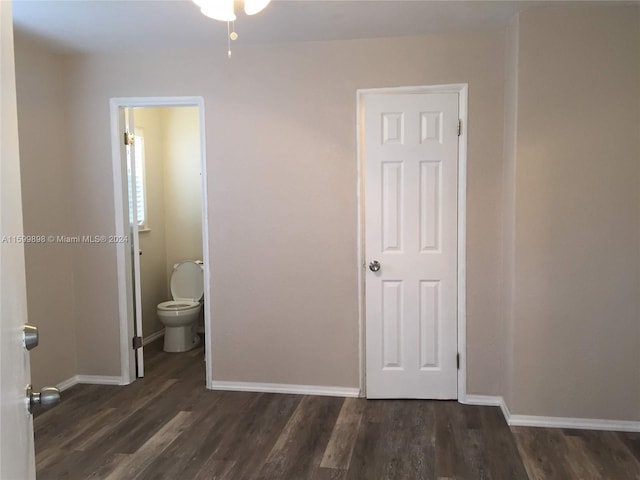 unfurnished bedroom with ensuite bathroom and dark hardwood / wood-style flooring