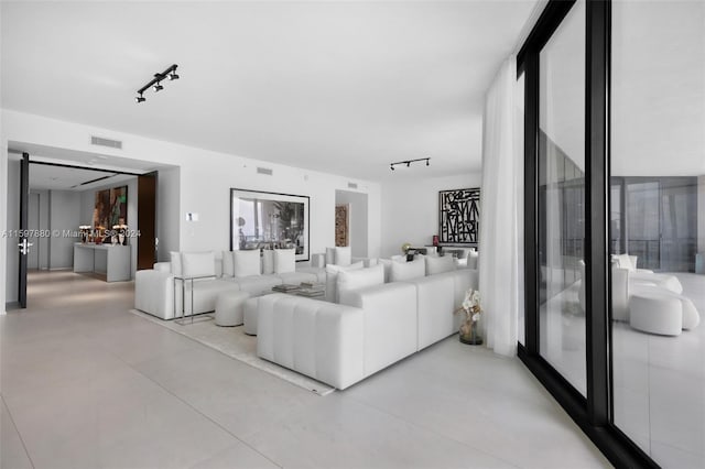 tiled living room featuring rail lighting