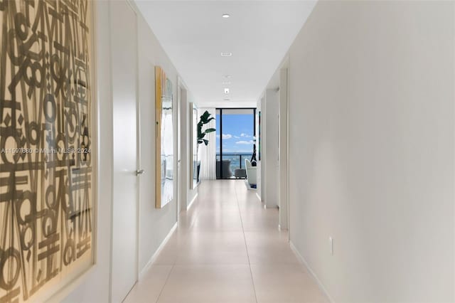 hallway featuring floor to ceiling windows and light tile flooring