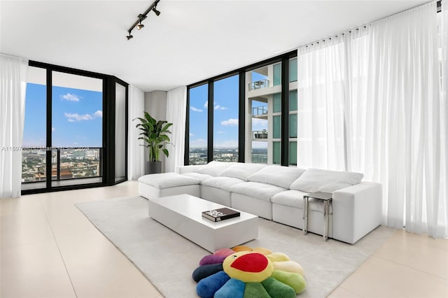 tiled living room featuring rail lighting and a wall of windows