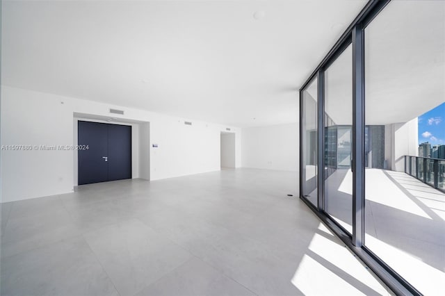 tiled empty room featuring expansive windows