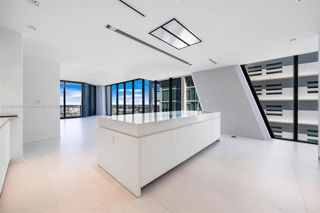 living room with floor to ceiling windows and light tile flooring