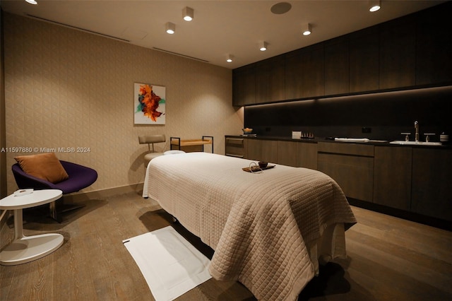 bedroom with sink and light hardwood / wood-style flooring