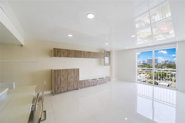 spare room with a view of city, recessed lighting, light tile patterned floors, and baseboards