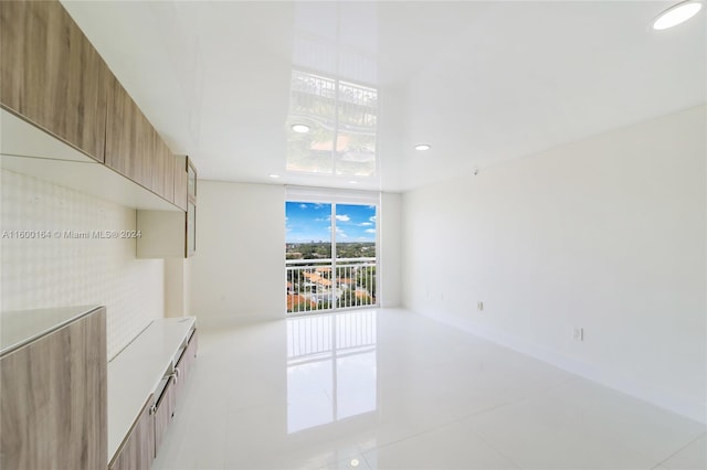 spare room featuring light tile patterned flooring, recessed lighting, and expansive windows