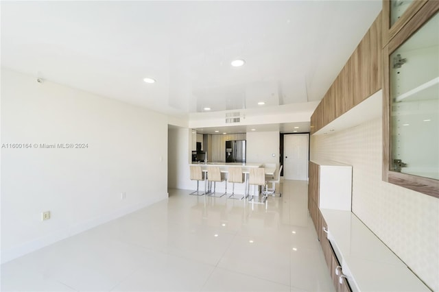 living room featuring light tile patterned flooring, baseboards, and recessed lighting
