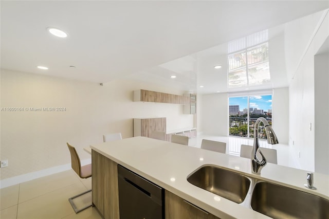 kitchen featuring stainless steel dishwasher, a sink, light countertops, modern cabinets, and recessed lighting