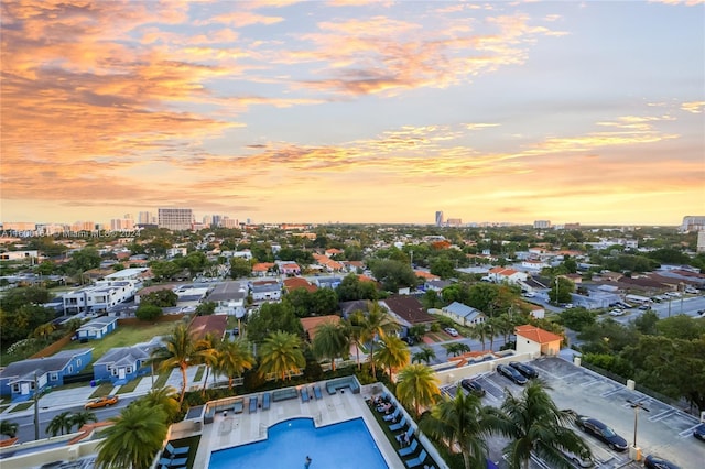 aerial view at dusk of a city view and view of pool