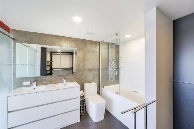 full bathroom featuring tile patterned floors, enclosed tub / shower combo, vanity, tile walls, and toilet