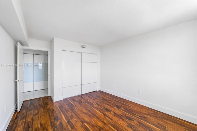 unfurnished bedroom with a closet and hardwood / wood-style floors