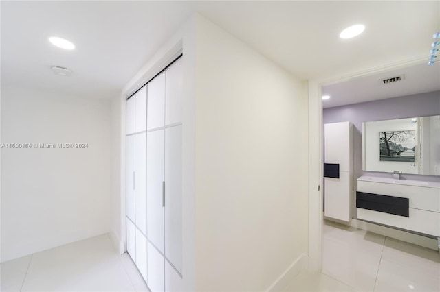 hall featuring recessed lighting, light tile patterned floors, and baseboards