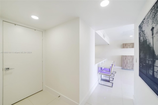 corridor featuring tile patterned flooring, recessed lighting, and baseboards