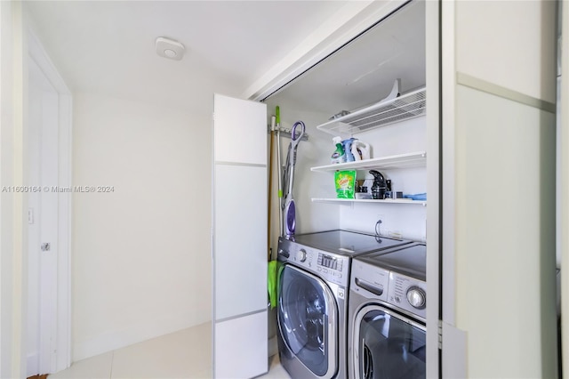 clothes washing area with tile patterned flooring and washer and dryer