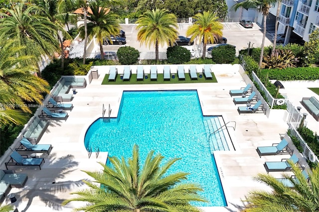community pool with a patio and fence