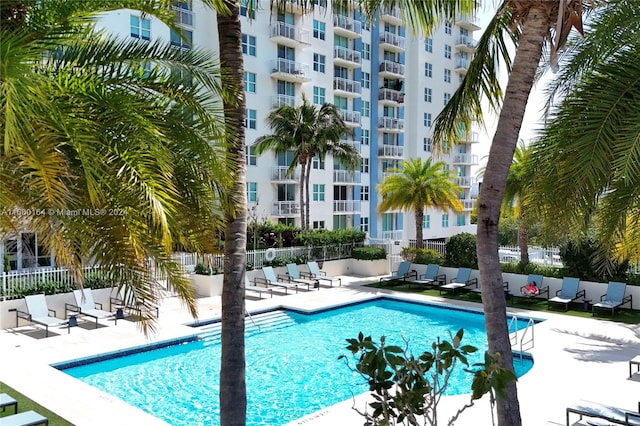 community pool featuring fence and a patio area