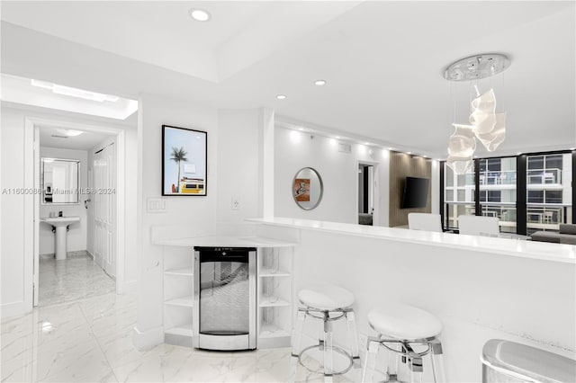 kitchen featuring pendant lighting, light tile patterned floors, a breakfast bar area, and wine cooler