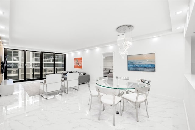 tiled dining space featuring a raised ceiling