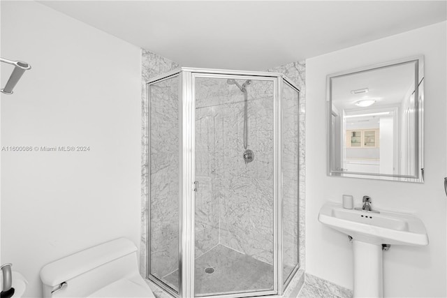 bathroom with a shower with shower door and toilet