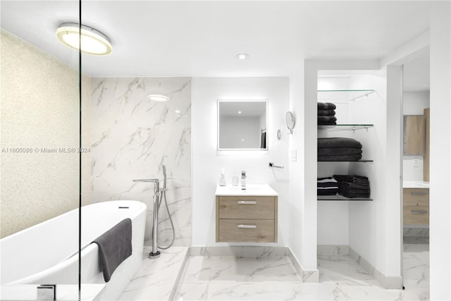 bathroom featuring a tub, tile patterned floors, tile walls, and vanity