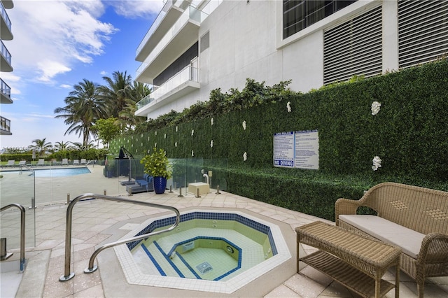 view of swimming pool with a patio area and a hot tub