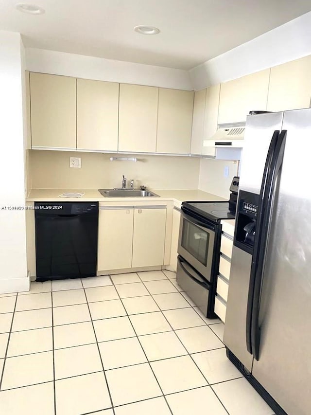 kitchen with stainless steel appliances, sink, cream cabinets, and premium range hood