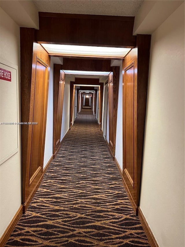 corridor with dark colored carpet