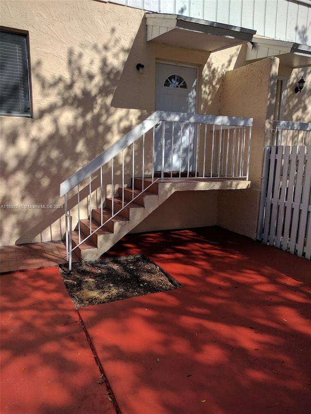 property entrance featuring board and batten siding and stucco siding