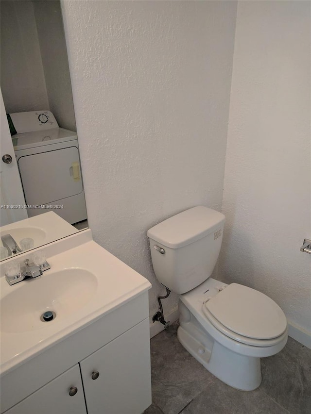 bathroom with washer / dryer, tile patterned floors, toilet, and vanity