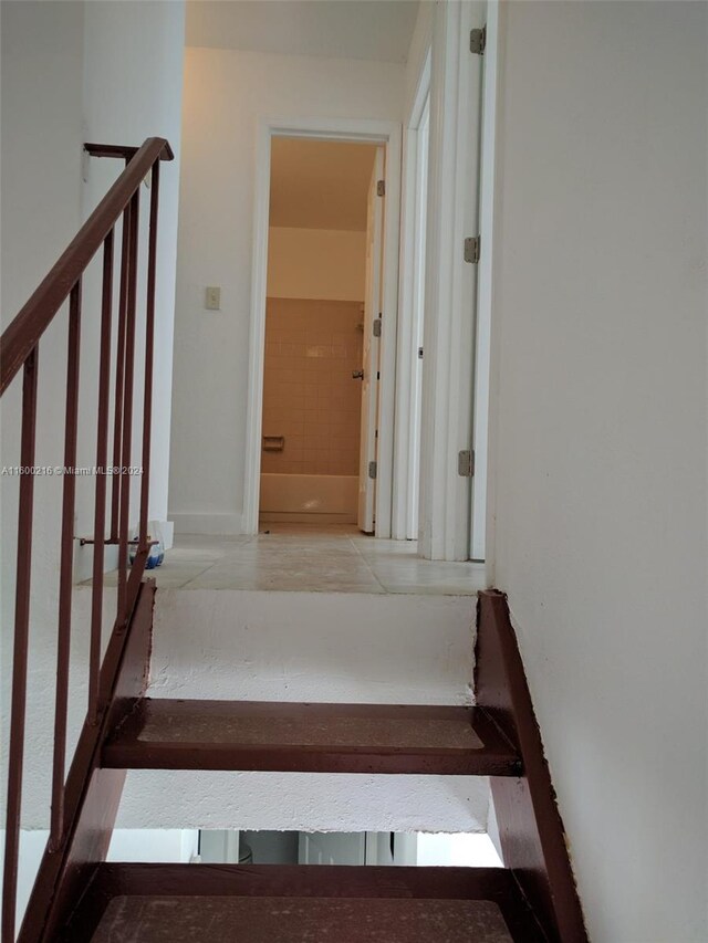 staircase featuring tile patterned flooring