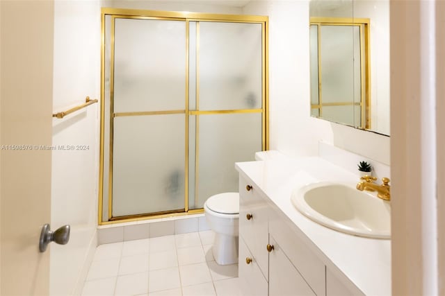 bathroom with toilet, vanity, an enclosed shower, and tile patterned flooring