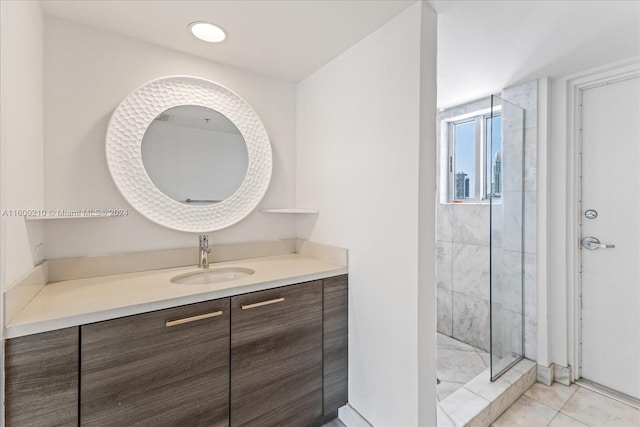 bathroom with tile patterned floors, vanity, and a tile shower