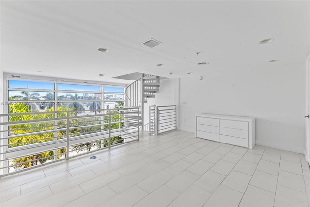 tiled empty room featuring expansive windows