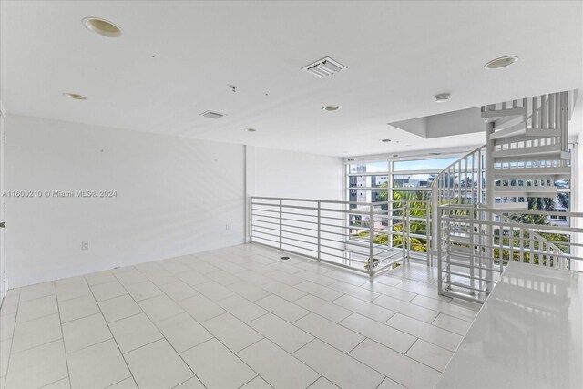 spare room featuring light tile patterned floors and floor to ceiling windows