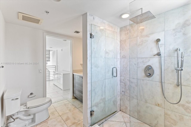 bathroom featuring tile patterned flooring, toilet, and a shower with door