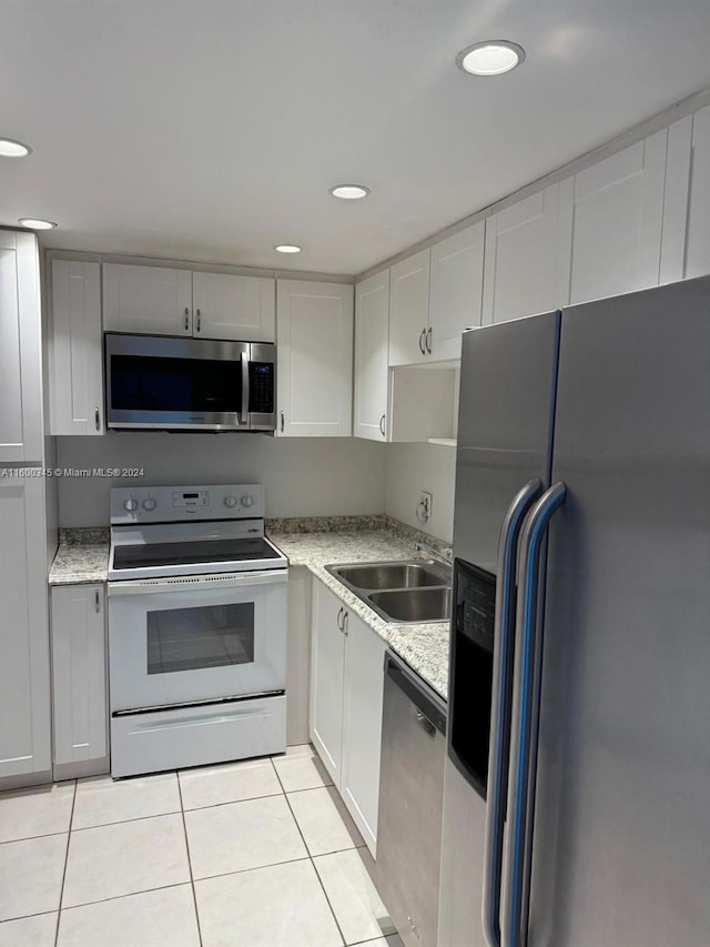 400 Kings Point Dr Unit 719, Sunny Isles Beach, FL 33160 - kitchen with appliances with stainless steel finishes, a sink, light tile patterned floors, recessed lighting, and white cabinets