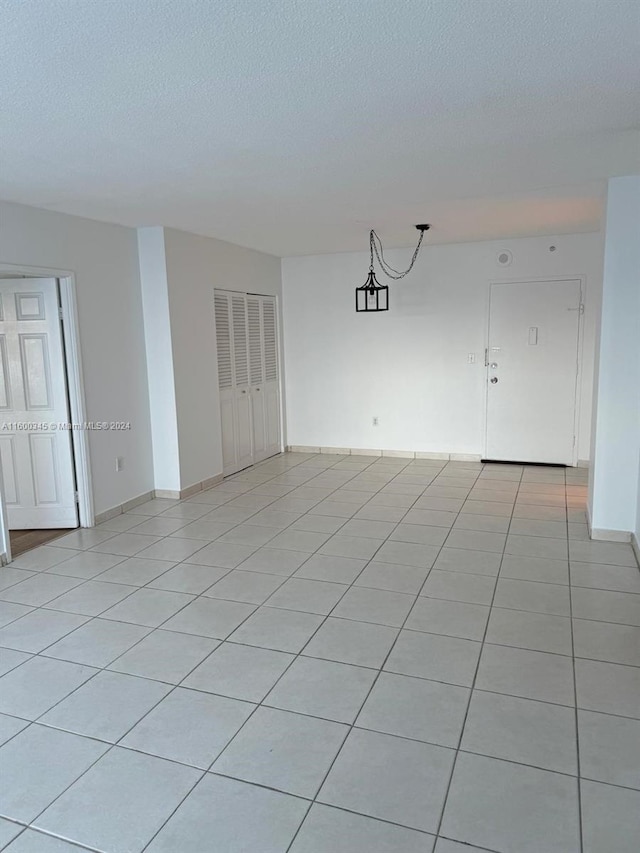 tiled empty room with a textured ceiling