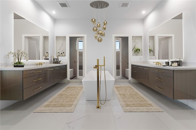 full bath featuring a freestanding tub, two vanities, and visible vents